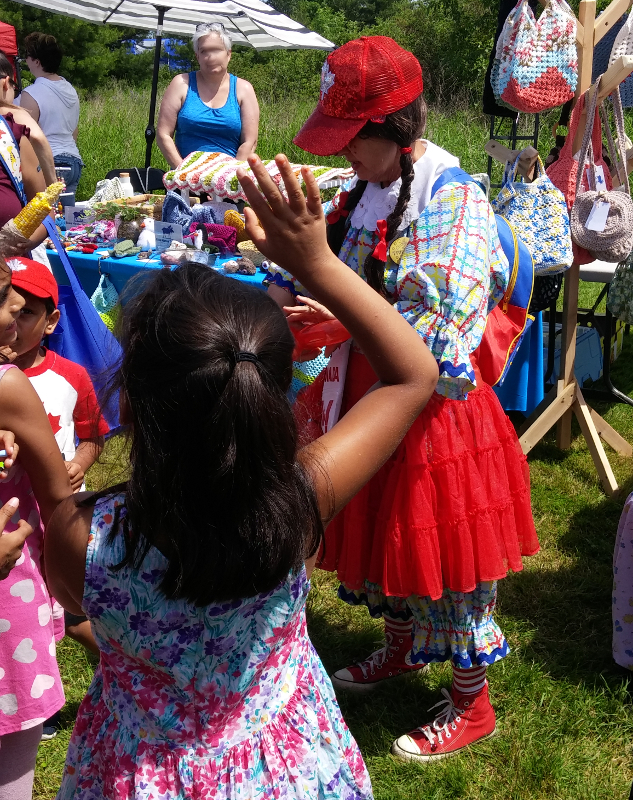 2019 Ajax-Pickering Canada Day, Scarborough Corp of Clowns, Tripper, in action, doing balloons for enthusiastic kids
