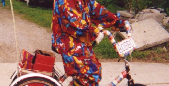 Bobbo, a long time ago, riding his tricycle in a parade.